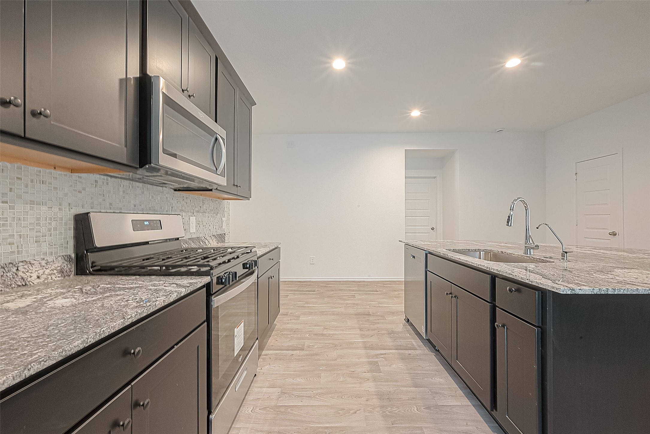 2731 Willow Gulch Way Rosenberg, TX 77469 - Photo 16 of 50 a kitchen with stainless steel appliances granite countertop a sink a stove and a wooden floors