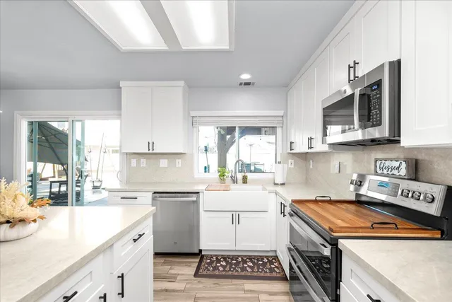 a kitchen with a sink a stove and cabinets