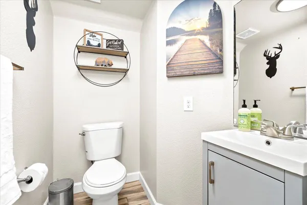 a bathroom with a toilet sink vanity and mirror