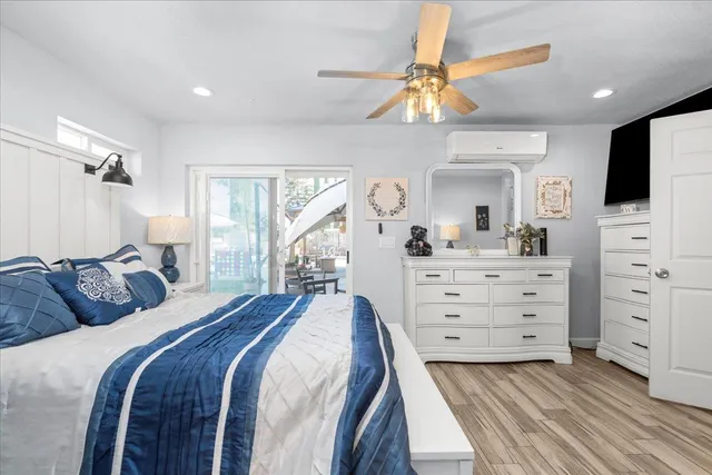 a bedroom with a bed and a flat tv screen on dresser