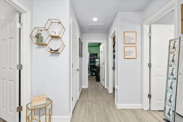 a view of a hallway with wooden floor and entryway