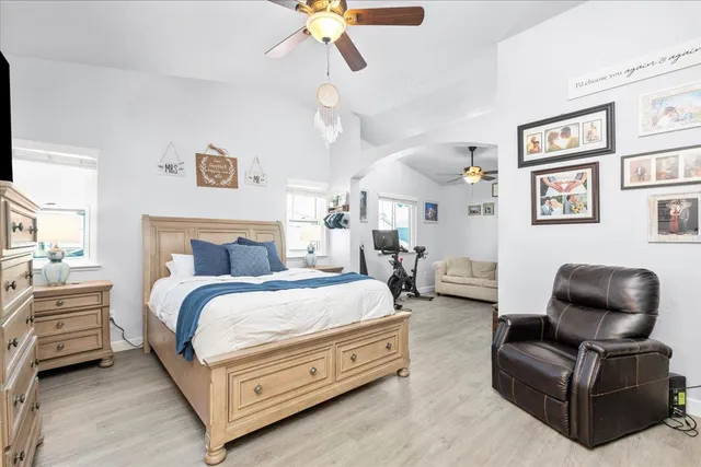 a spacious bedroom with a bed a couch and a chandelier