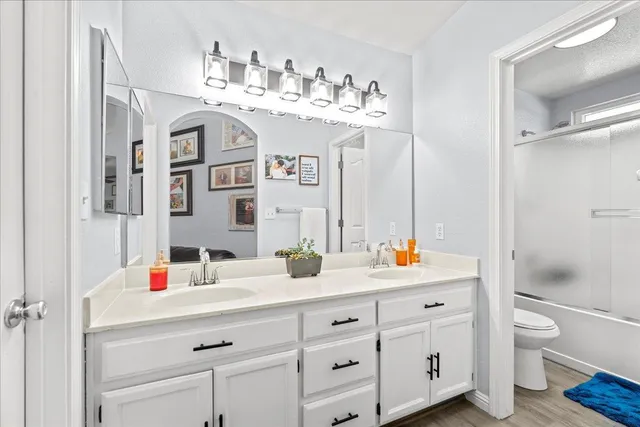 a spacious bathroom with a double vanity sink mirror and toilet