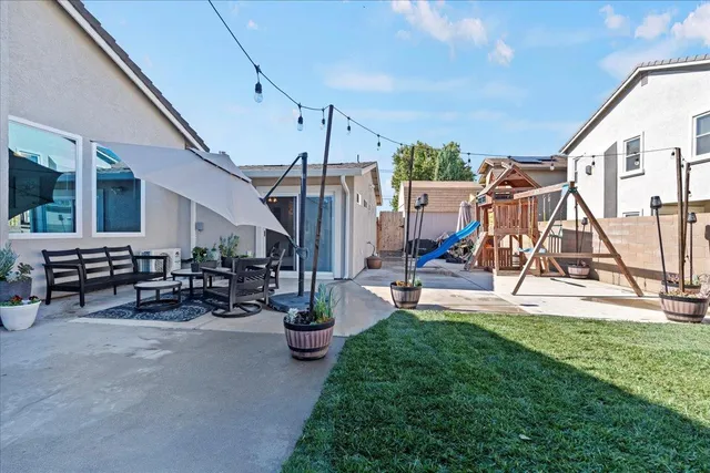 a view of a house with backyard and sitting area