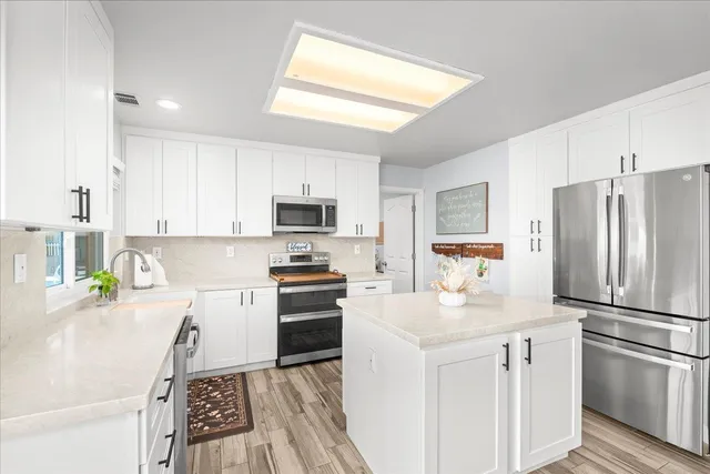 a kitchen with stainless steel appliances a refrigerator sink and microwave