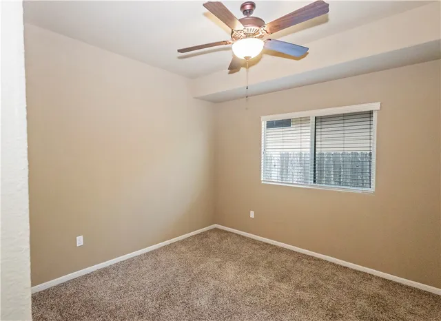 a view of a livingroom with a chandelier fan and windows