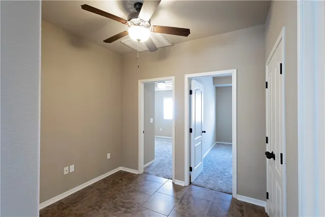 an empty room with a window and a fan