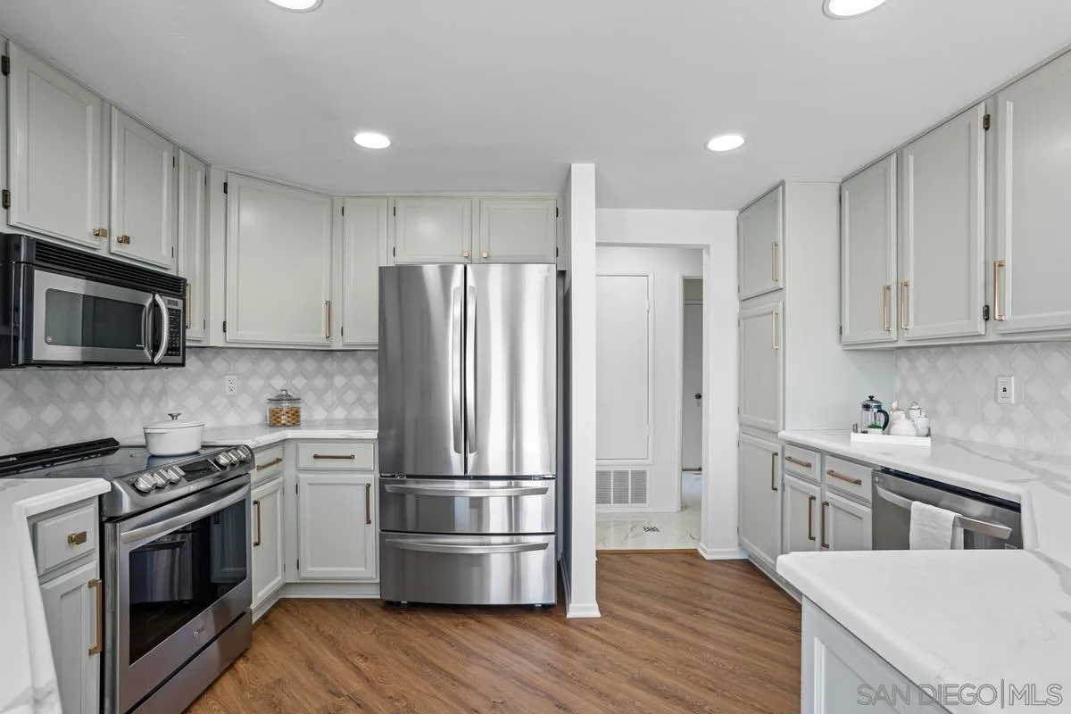 1201 Rue St Jean San Marcos, CA 92078 - Photo 12 of 73 a kitchen with wooden cabinets and stainless steel appliances