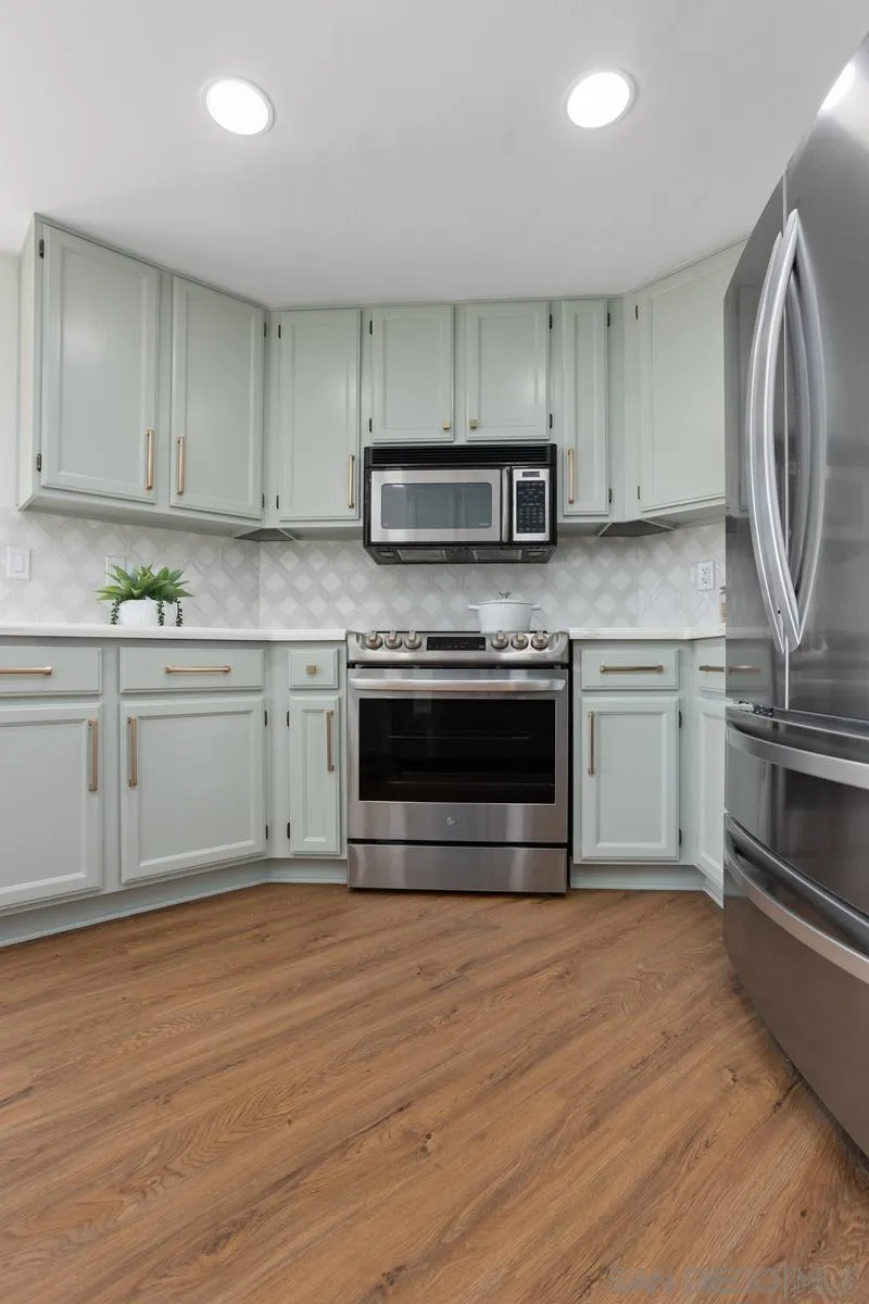 1201 Rue St Jean San Marcos, CA 92078 - Photo 45 of 73 a kitchen with stainless steel appliances granite countertop a stove a sink and a microwave