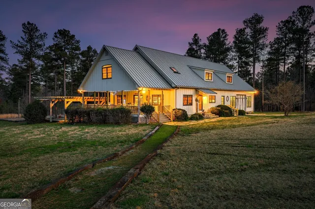 a view of a big house with a big yard and large trees