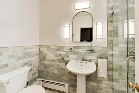 a bathroom with a toilet a sink and a mirror