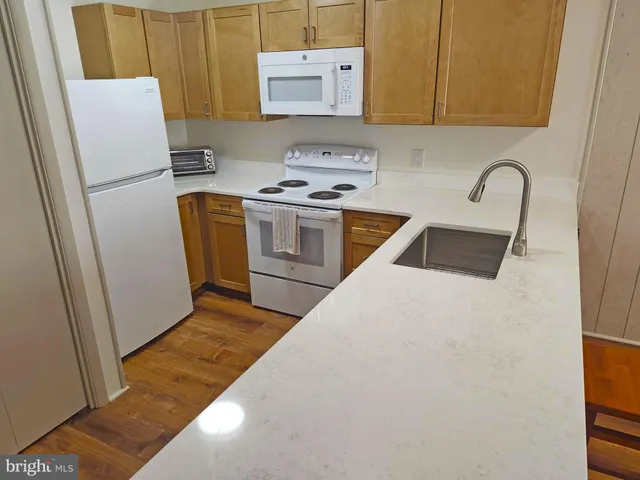 a kitchen with a refrigerator a stove a sink and a window