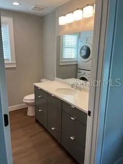 a bathroom with a sink toilet mirror and window