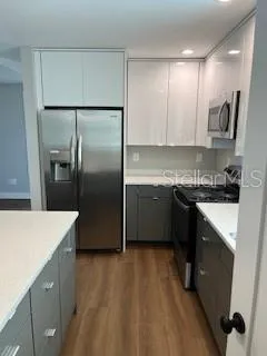 a kitchen with a sink a refrigerator and cabinets