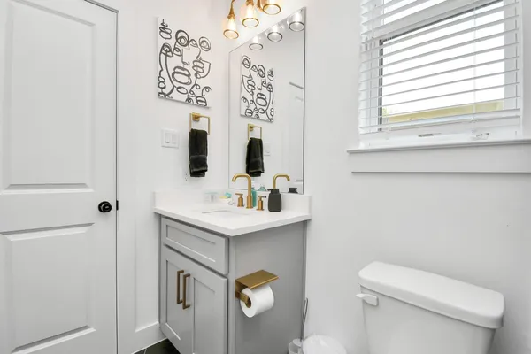 a bathroom with a toilet sink and mirror