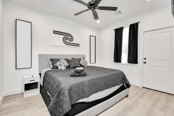 a bedroom with a large bed and a chandelier