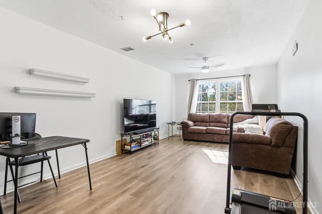 a living room with furniture gym equipment and a chandelier