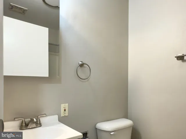 a bathroom with a toilet a sink and mirror