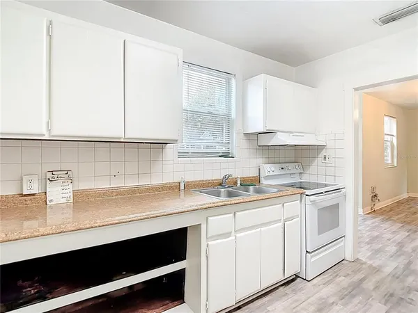 a kitchen with white cabinets and white appliances