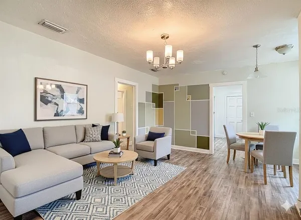 a living room with furniture wooden floor and dining table