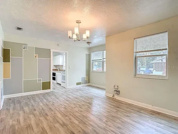 a view of empty room with wooden floor