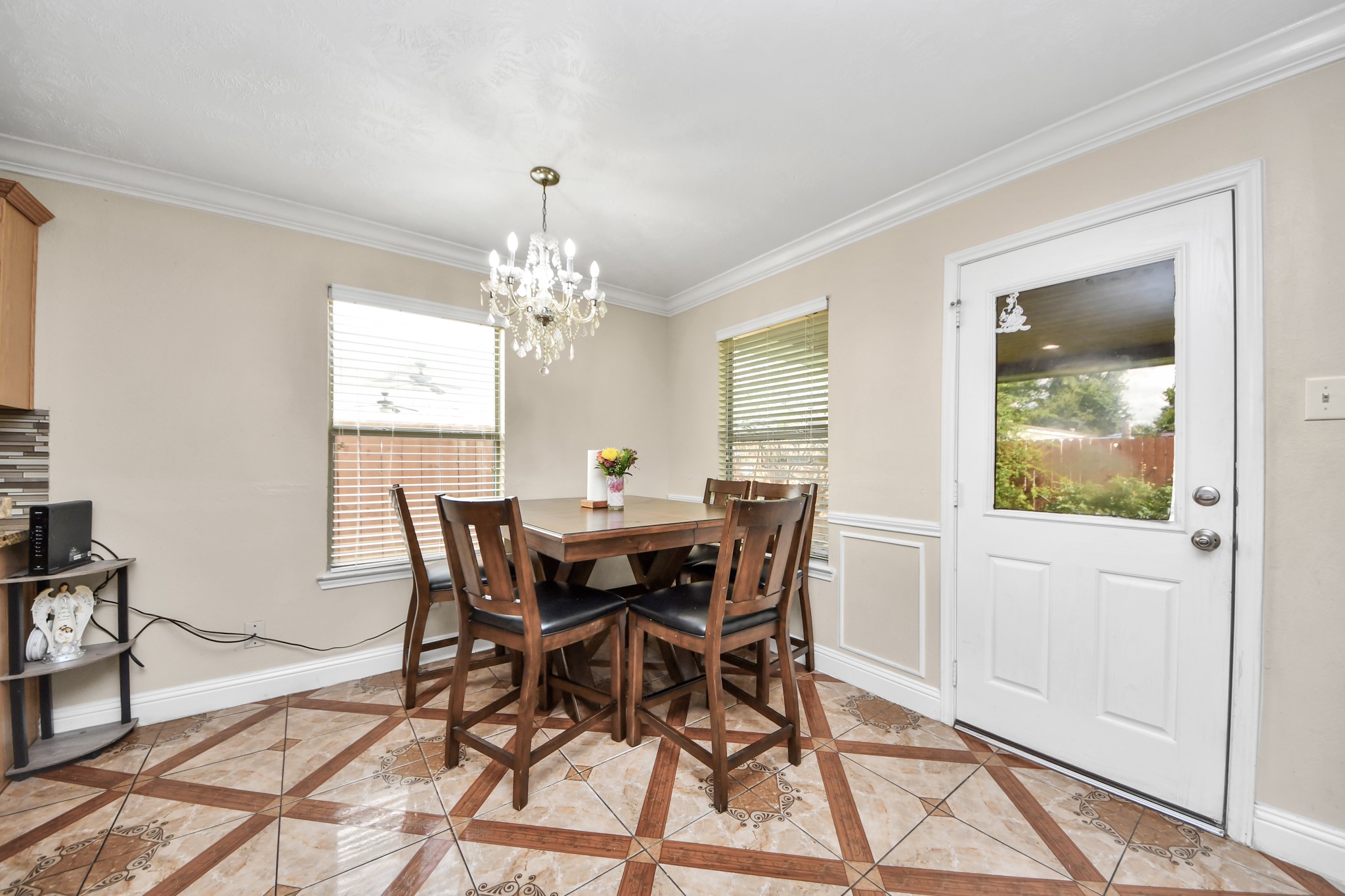 9250 Strawberry Cactus Loop Houston, TX 77064 - Photo 13 of 26 Bright dining area with elegant chandelier, featuring tile flooring and natural light from multiple windows, perfect for cozy meals.