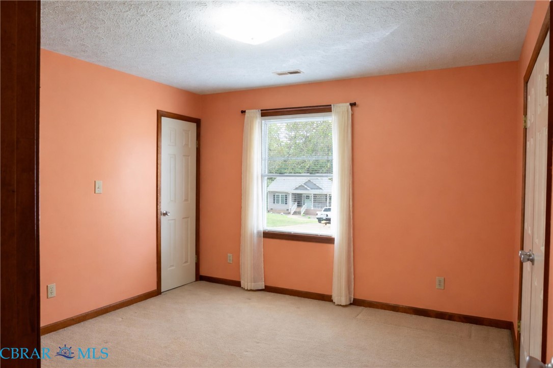 2847 Decatur Drive Hayes, VA 23072 - Photo 28 of 30 Unfurnished bedroom featuring light carpet, a closet, and a textured ceiling