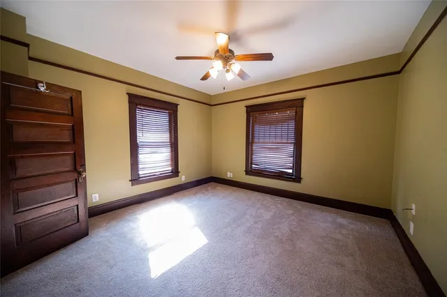 a view of an empty room with a fireplace and a window