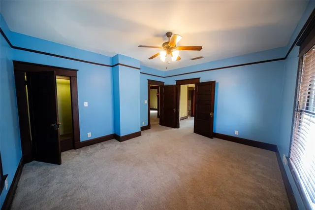 an empty room with closet and a chandelier fan