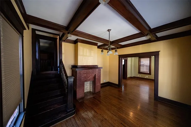 a view of a hallway with wooden floor and stairs