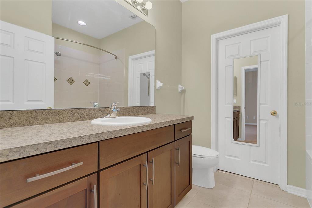 543 Rainbow Springs Loop Groveland, FL 34736 - Photo 13 of 26 a bathroom with a granite countertop sink a toilet and a mirror