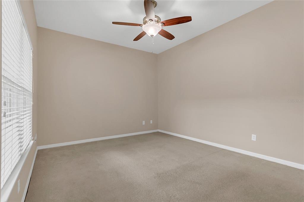 543 Rainbow Springs Loop Groveland, FL 34736 - Photo 16 of 26 an empty room with a chandelier fan and windows
