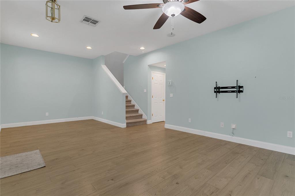 543 Rainbow Springs Loop Groveland, FL 34736 - Photo 5 of 26 an empty room with wooden floor ceiling fan and windows
