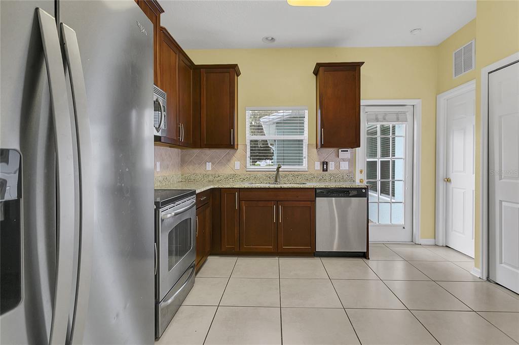 543 Rainbow Springs Loop Groveland, FL 34736 - Photo 10 of 26 a kitchen with stainless steel appliances granite countertop a refrigerator and a sink