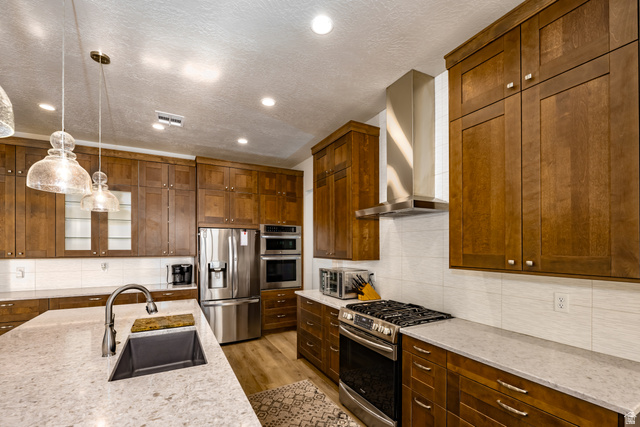 1283 North Gallen Road Santa Clara, UT 84765 - Photo 21 of 103 Kitchen with stainless steel appliances, tasteful backsplash, light stone counters, glass insert cabinets, and a textured ceiling