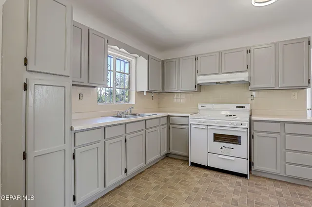 a kitchen with cabinets appliances a sink and a window