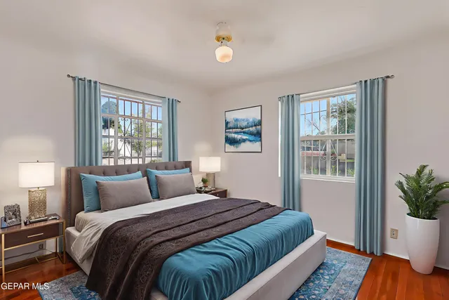 a bedroom with a large bed and a potted plant