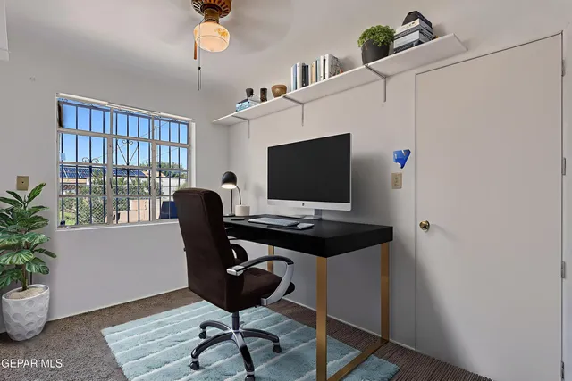 a view of a workspace with furniture and a window