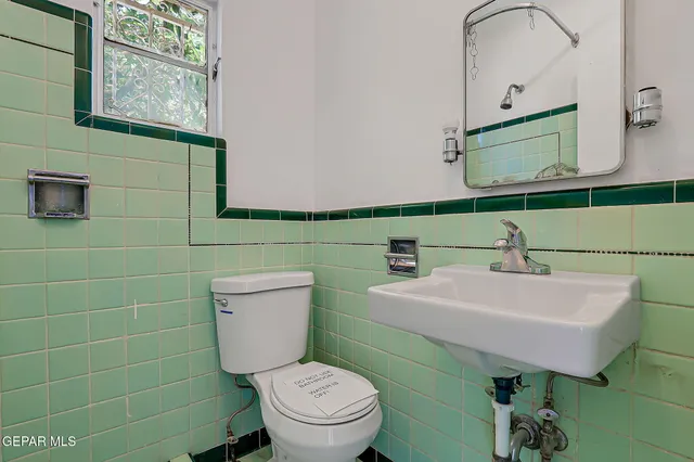 a bathroom with a toilet sink and mirror