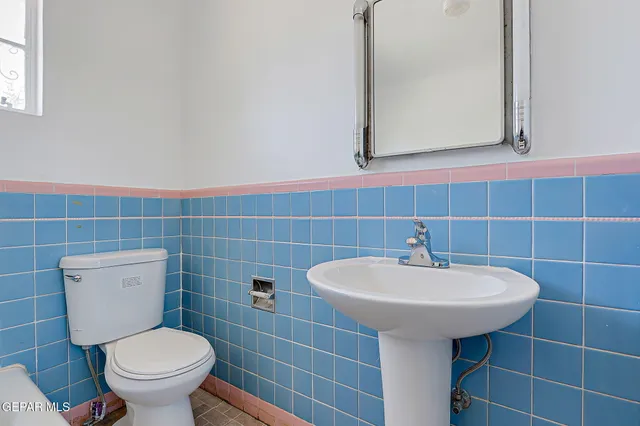 a bathroom with a sink a toilet and a mirror