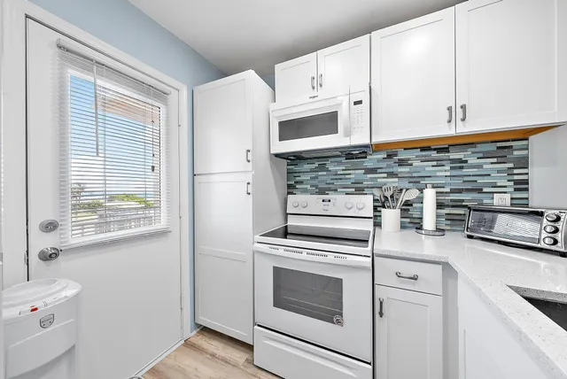 a kitchen with stainless steel appliances white cabinets and a stove top oven