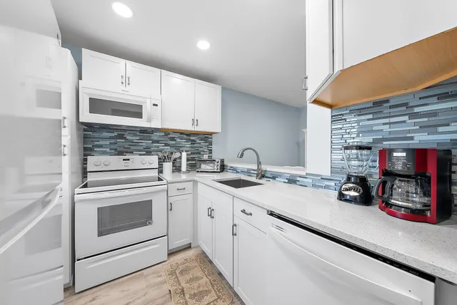 a kitchen with stainless steel appliances granite countertop a sink stove and cabinets