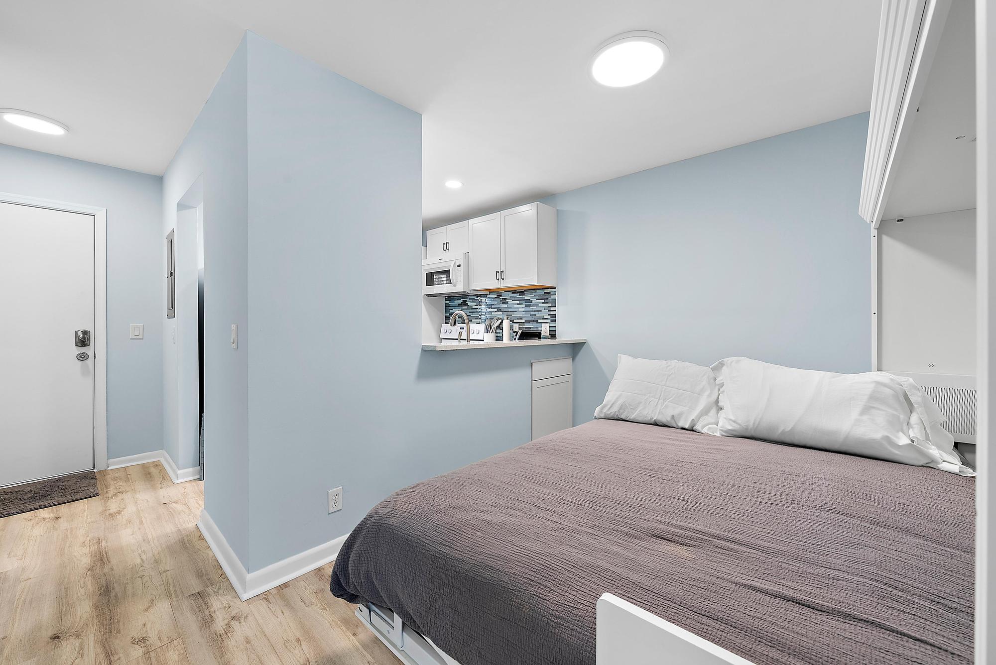 3851 North Ocean Boulevard, Unit 202 Gulf Stream, FL 33483 - Photo 9 of 20 a bedroom with a bed and painting on the wall