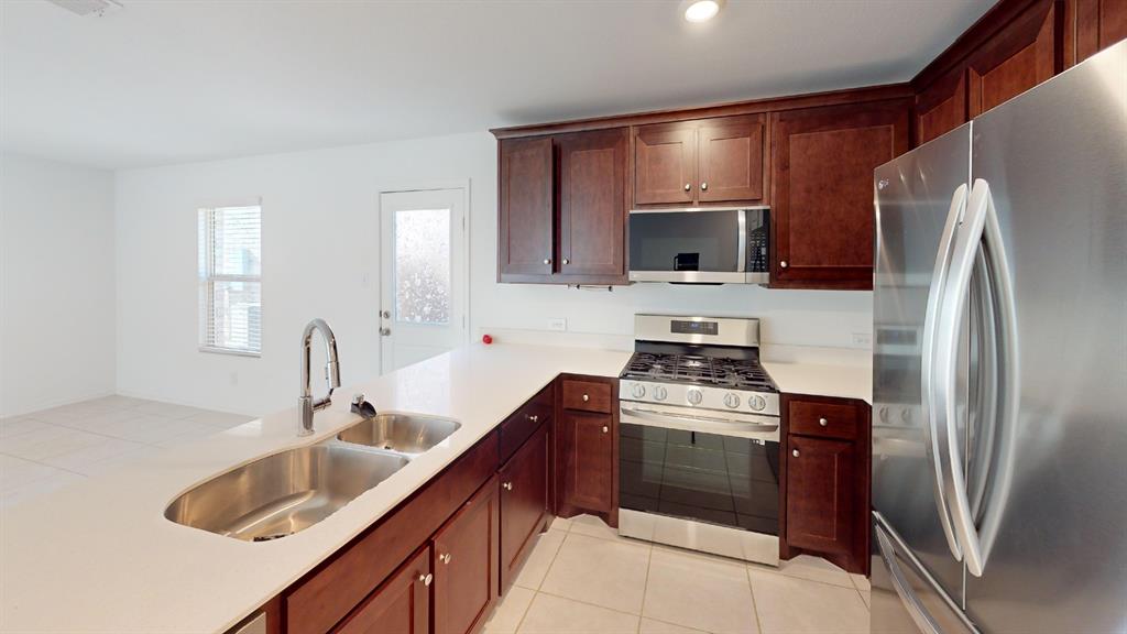 14065 Haggerston Drive Pilot Point, TX 76258 - Photo 4 of 21 a kitchen with a sink stove and refrigerator
