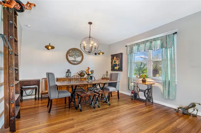 a kitchen with stainless steel appliances granite countertop a table chairs and a refrigerator