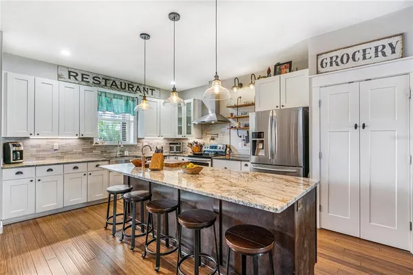 a kitchen with granite countertop a sink appliances and cabinets