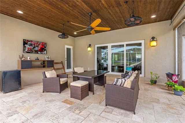 a living room with patio furniture and a floor to ceiling window