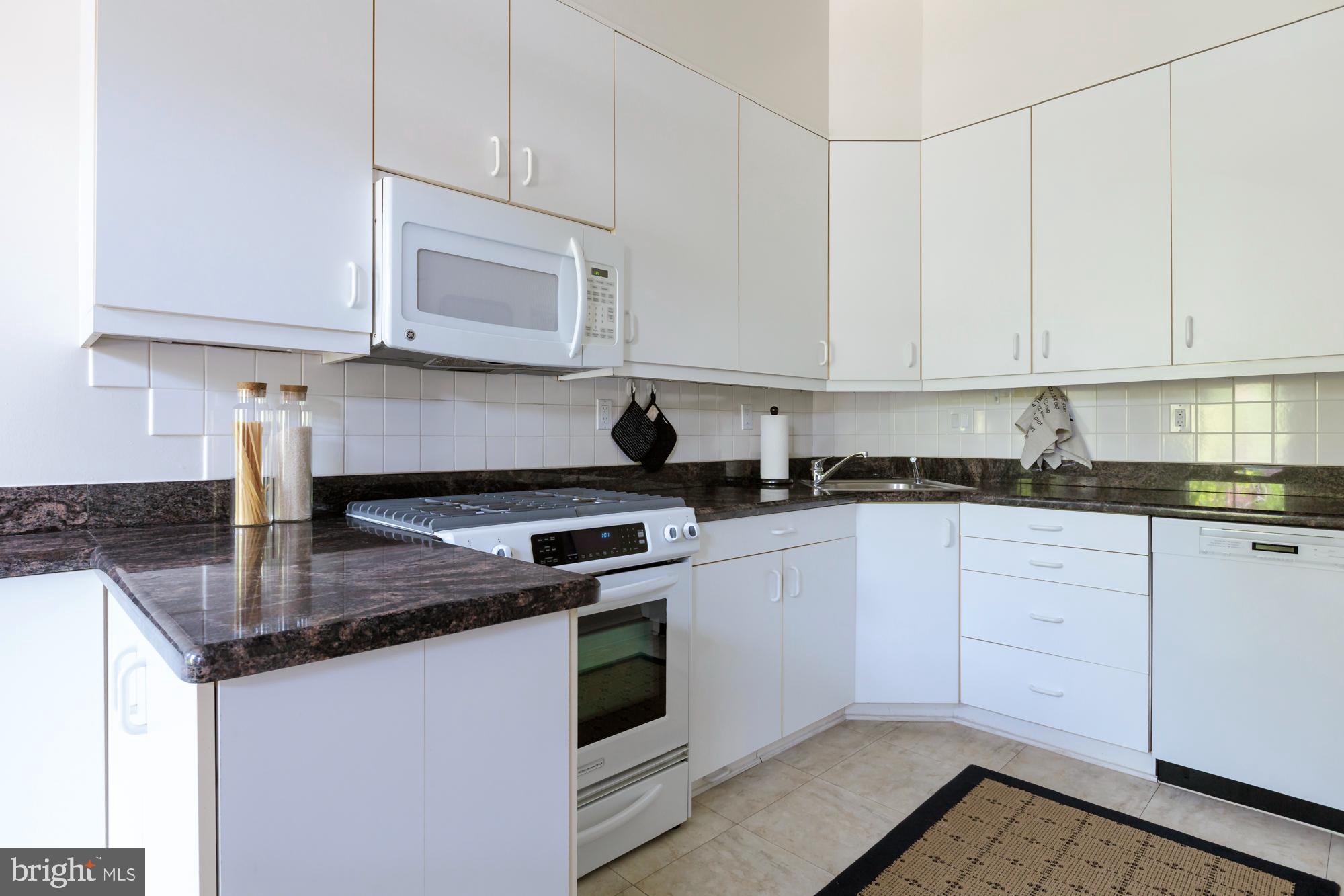 244 8th Street Southeast Washington, DC 20003 - Photo 17 of 53 a kitchen with stainless steel appliances granite countertop a sink a stove and white cabinets