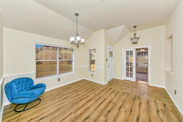 a view of a livingroom with wooden floor and a chandelier