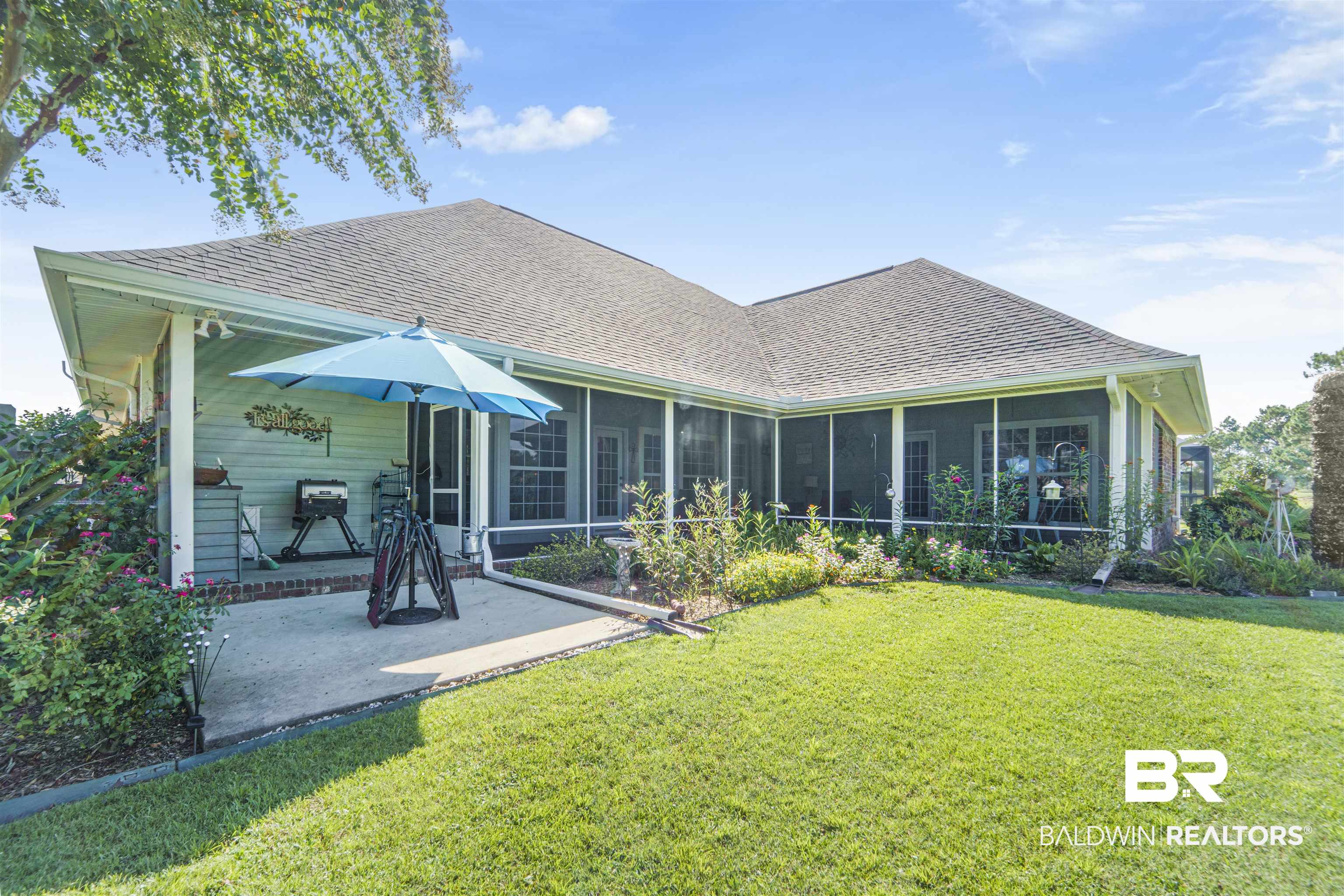 9505 Lakeview Drive Foley, AL 36535 - Photo 35 of 38 Rear view of house featuring roof with shingles, a sunroom, and a yard